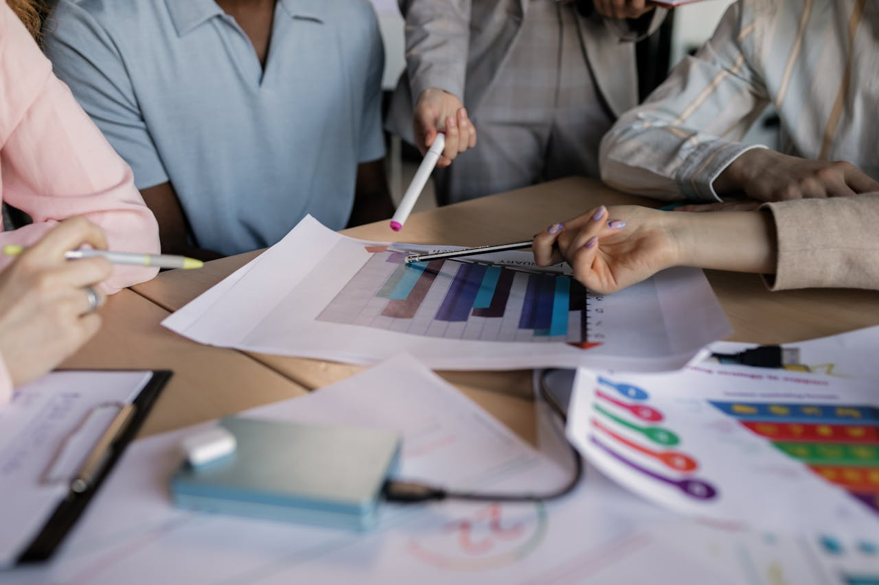 Crafting Captivating Headlines: Your awesome post title goes here A diverse team engaged in planning and discussing a business strategy around a wooden table indoors.